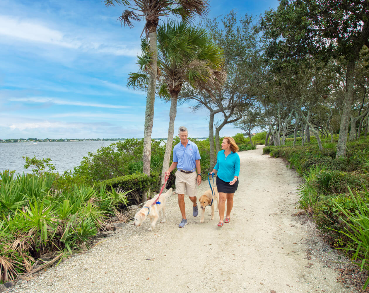 Couple walking dog on path