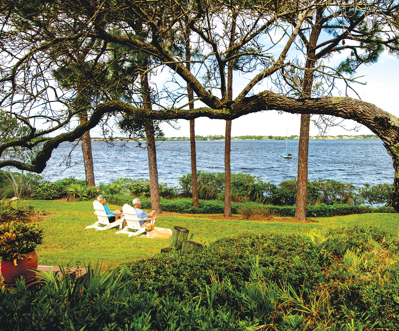 Men sitting in Adirondack chairs by water