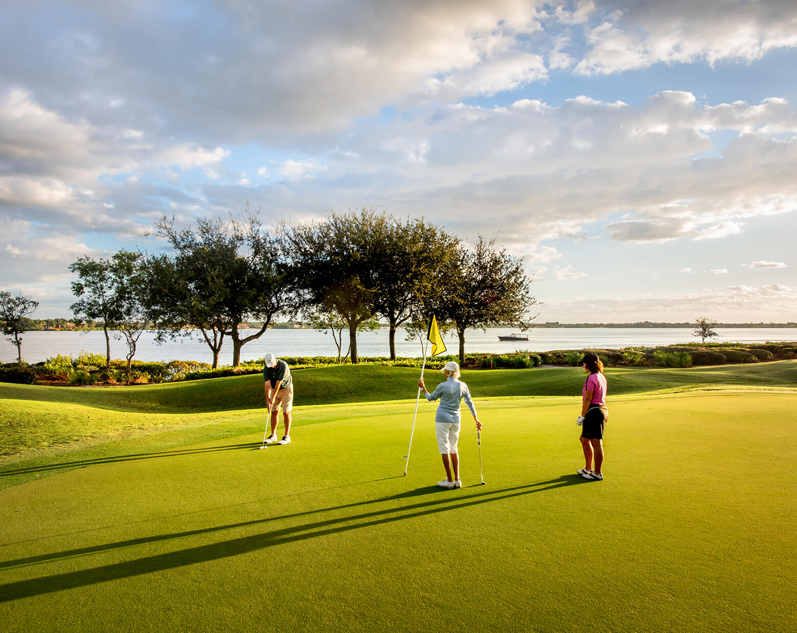 golfers on green with yellow flag