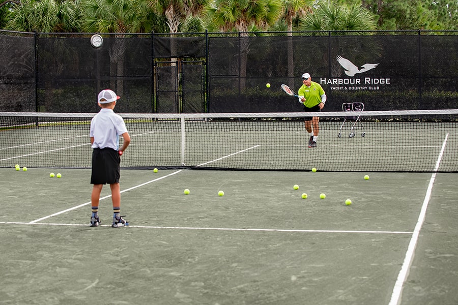harbour ridge member playing tennis with grandson